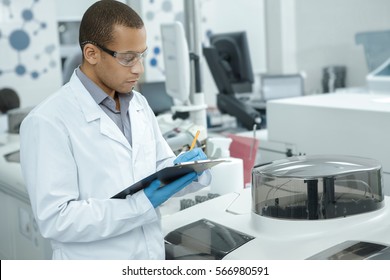 Medical Research. Professional Chemist Young African Man Writing On His Clipboard While Working At The Laboratory Ethnicity Profession Occupation People Medicine Clinical Biology Internship Copyspace