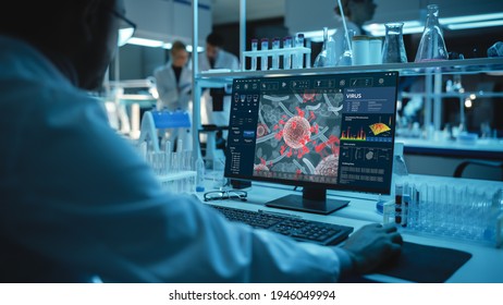 Medical Research Scientist Working on Desktop Computer with Virus Analysis Software in Modern Science Research Laboratory. Lab Engineers in White Coats Conduct Experiments in the Background. - Powered by Shutterstock