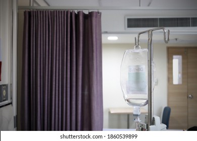 Medical Saline Drip Hanging On A Stand Hospital Treatment Room Concept With Privacy Curtains