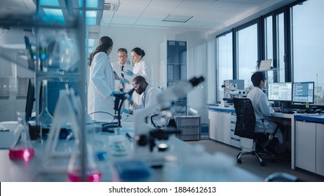 Medical Science Laboratory With Diverse Multi-Ethnic Team Of Microbiology Scientists Have Meeting On Developing Drugs, Medicine, Doing Biotechnology Research. Working On Computers, Analyzing Samples