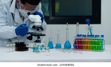 Medical Science Laboratory: A Scientist Looking Under A Microscope Analyzes A Test Sample. Ambitious Young Biotechnology Specialist Work With The Device