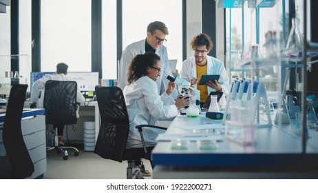 Medical Science Laboratory: Shot of Diverse Team Young Scientists Doing Analysis of Test Sample with Use of Microscope. Ambitious Young Biotechnology Specialists, working with Advanced Equipment - Powered by Shutterstock