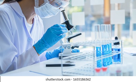 Medical or scientific researcher or man doctor looking at a test tube of clear solution in a laboratory