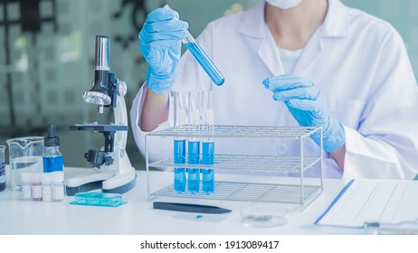 Medizinischer oder wissenschaftlicher Forscher oder Humanarzt, der in einem Labor eine Teströhre mit einer klaren Lösung untersucht