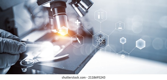 Medical scientist close up microscope researching medicine cure for illness disease and virus concept, abstract illustration banner with graphical science icon strand hologram, banner background - Powered by Shutterstock