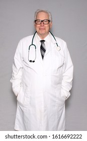 Medical Or Scientist. A Doctor Or Researcher Wears A White Lab Coat. Gray Background.  Friendly Doctor Or Lab Assistant. Room For Text Overlay. Medical Professional. 