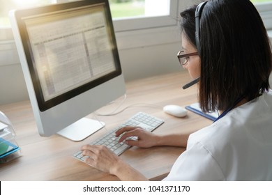 Medical secretary typing report on deskop computer