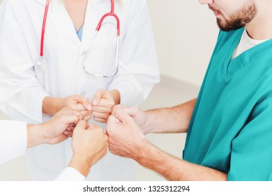 Medical service teamwork - Doctor, surgeon and nurse join hands together. - Shutterstock ID 1325312294