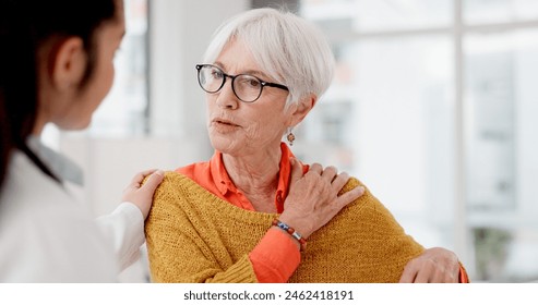 Medical, shoulder pain and a senior woman with her doctor in the hospital, talking during a consultation. Healthcare, insurance or anatomy and a woman patient in a clinic with a medicine professional - Powered by Shutterstock