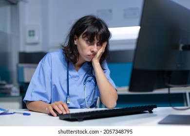 Medical specialist falling asleep at desk and using computer, working late at night. Woman assistant feeling burnout and exhaustion after doing overtime work on monitor for healthcare
