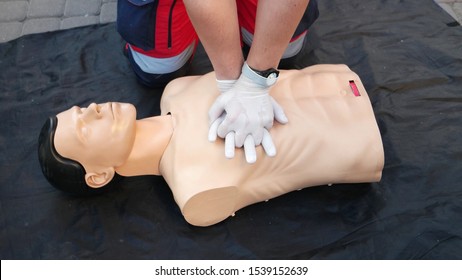 Medical specialist shows the correct position of the hand when performing a cardiopulmonary resuscitation on a medical training