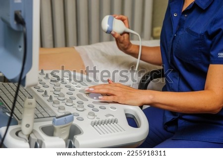 Medical specialists near ultrasound machine in the hospital ward.