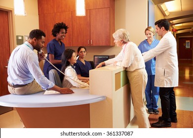 Medical Staff At Busy Nurse's Station In Hospital - Powered by Shutterstock