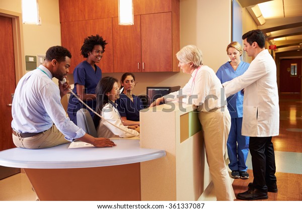 Medical Staff\
At Busy Nurse\'s Station In\
Hospital