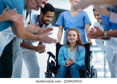 Medical staff clapping to little girl patient who recovered from serious illness. - Powered by Shutterstock