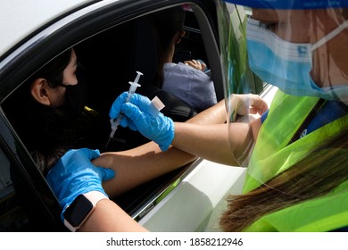 A medical staff gives a drive-thru attendee an influenza vaccine during a drive-thru free flu shots to members of the Los Angeles community at Cal State LA parking lot in Los Angeles, Nov. 20, 2020.
