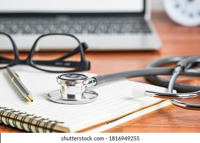 Medical Stethoscope For Doctor Checkup With Laptop Computer On Doctor Note Pad As Medical Concept