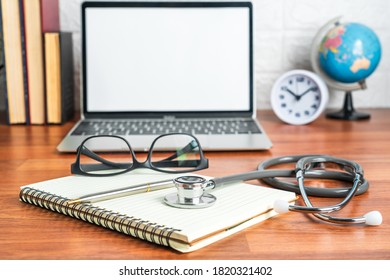 Medical Stethoscope For Doctor Checkup With Laptop Computer On Doctor Note Pad As Medical Concept