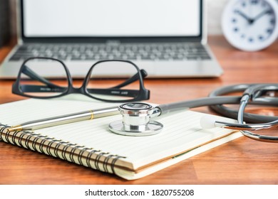 Medical Stethoscope For Doctor Checkup With Laptop Computer On Doctor Note Pad As Medical Concept