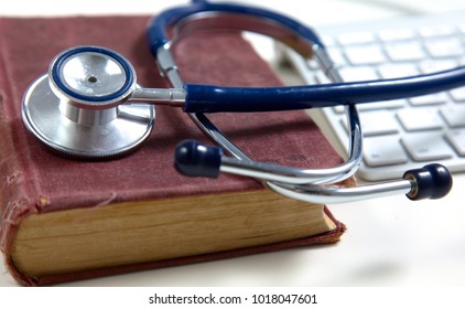 Medical Stethoscope With Old Books And Laptop On A Table