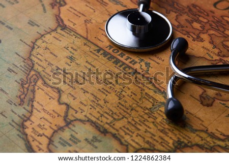 Medical stethoscope over North America healthcheck. Medical concept tourism travel care diseases healthy, close-up. Stethoscope on map background with copy space, top view, selective focus. 