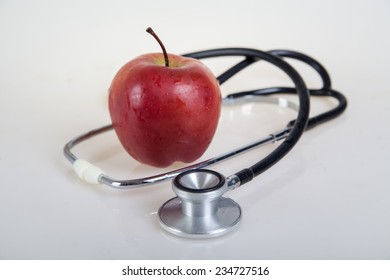 Medical stethoscope and red apple. Healty food