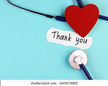 Medical Stethoscope, Red Healthy Heart And Thank You Doctor Text On Blue Background. Concept Of Gratitude To Health Workers During A Pandemic