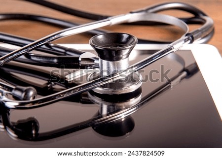 medical stethoscope and tablet on brown wooden background. Health care concept. phonendoscope.