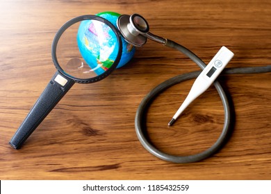 Medical stethoscope, thermometer and global world isolated on wooden floor  background. Sign and symbol for take care of health of planet, economy, environment, global warming concept.    