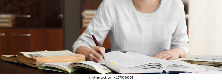 Medical student preparing for classes in university. Woman makes notes at her workplace. Education concept.