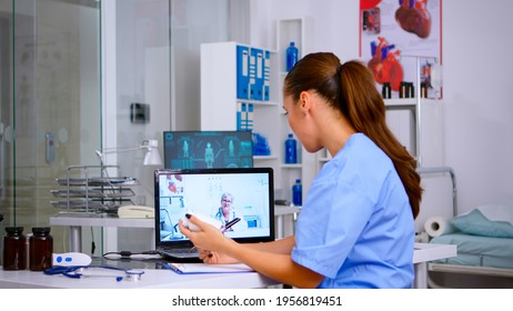 Medical student talking during video health conference with senior doctor, listening advices and taking notes. Remote healthcare service, virtual meeting, telemedicine, online video call webinar. - Shutterstock ID 1956819451