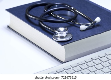 Medical Student Textbook With Black Stethoscope And Modern White Computer Keyboard Isolated On White Surface Background