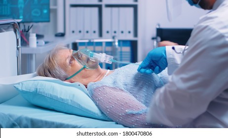 Medical stuff adjusting oxygen mask on senior woman who lies in hospital bed fighting with coronavirus covid-19 symptoms. Medicine medical healthcare system epidemic lungs infection treatment - Powered by Shutterstock