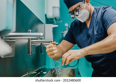 Medical surgeon cleaning hands before surgery inside hospital room  - Shutterstock ID 2012480600