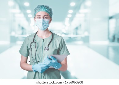 Medical Surgical Doctor And Health Care, Portrait Of Surgeon Doctor In PPE Equipment In Examination Room. Medicine Female Doctors Wearing Face Mask And Cap For Patients Surgery Work. Medic Hospital