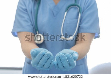 Medical surgical doctor or surgeon with empty hands in hygience lab gloves offering or holding copy space for health care practice, nursing, organ donation, hospital csr, or clinical charity concept