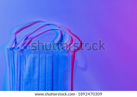 Medical surgical masks in club neon light. Abstract background of cyber colors of night streets