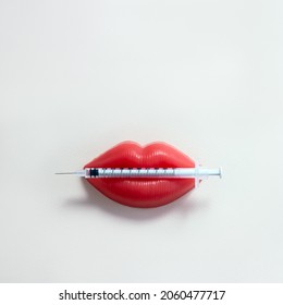 Medical syringe and plasticine lips. Lip injection creative concept. Selective focus, square orientation