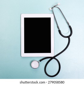 Medical Tablet With Stethoscope On Blue Background