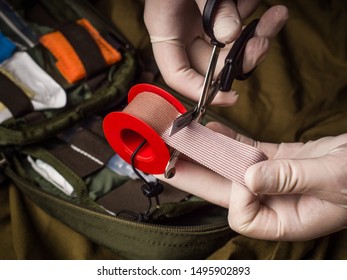 Medical Tape Cutting During First Aid In An Emergency. Hands In Latex Gloves Holding Trauma Shears