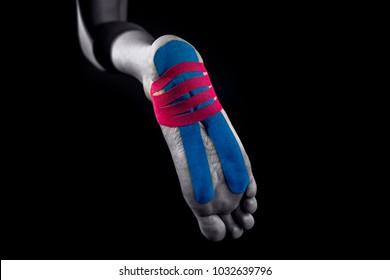 Medical taping for calcaneal spur and plantar fasciitis treatment showed on young model isolated on black background.