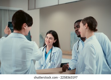 Medical teacher and interns analyzing the x-ray results of the patient's brain. before major surgery in the operating room - Powered by Shutterstock