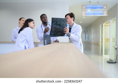 Medical teacher and interns analyzing the x-ray results of the patient's brain. before major surgery in the operating room - Powered by Shutterstock