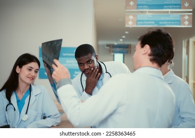 Medical teacher and interns analyzing the x-ray results of the patient's brain. before major surgery in the operating room - Powered by Shutterstock