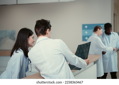 Medical teacher and interns analyzing the x-ray results of the patient's brain. before major surgery in the operating room - Powered by Shutterstock