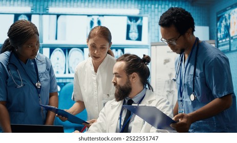 Medical team discusses x ray results and patient care strategy in a treatment center, expertise in radiology and disease prevention. Collaborative work ensures diagnosis and medicine. Camera A. - Powered by Shutterstock