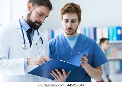 Medical Team At The Hospital Checking Paperwork And Patient's Medical Records, Healthcare And Teamwork Concept