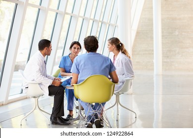 Medical Team Meeting Around Table In Modern Hospital