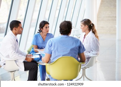 Medical Team Meeting Around Table In Modern Hospital