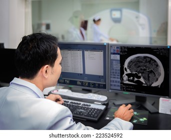 Medical Team Operating Computers In CT Scan Lab For Head Section